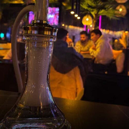 Nahaufnahme einer hochwertigen Shisha Bowl mit Rauch und gemütlichem Lounge-Hintergrund.