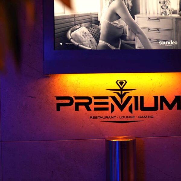 Das Logo der Premium Shisha Bar Hamburg, beleuchtet in warmem Gelb und Blau, mit dem Schriftzug "Restaurant, Lounge, Gaming".
