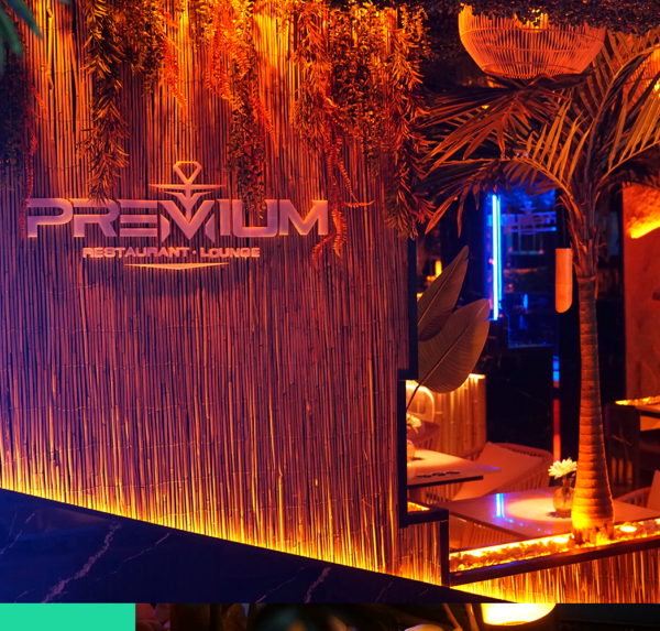 Elegante Shisha-Lounge mit warmem Licht, stilvoller Dekoration und Premium-Logo an der Wand.